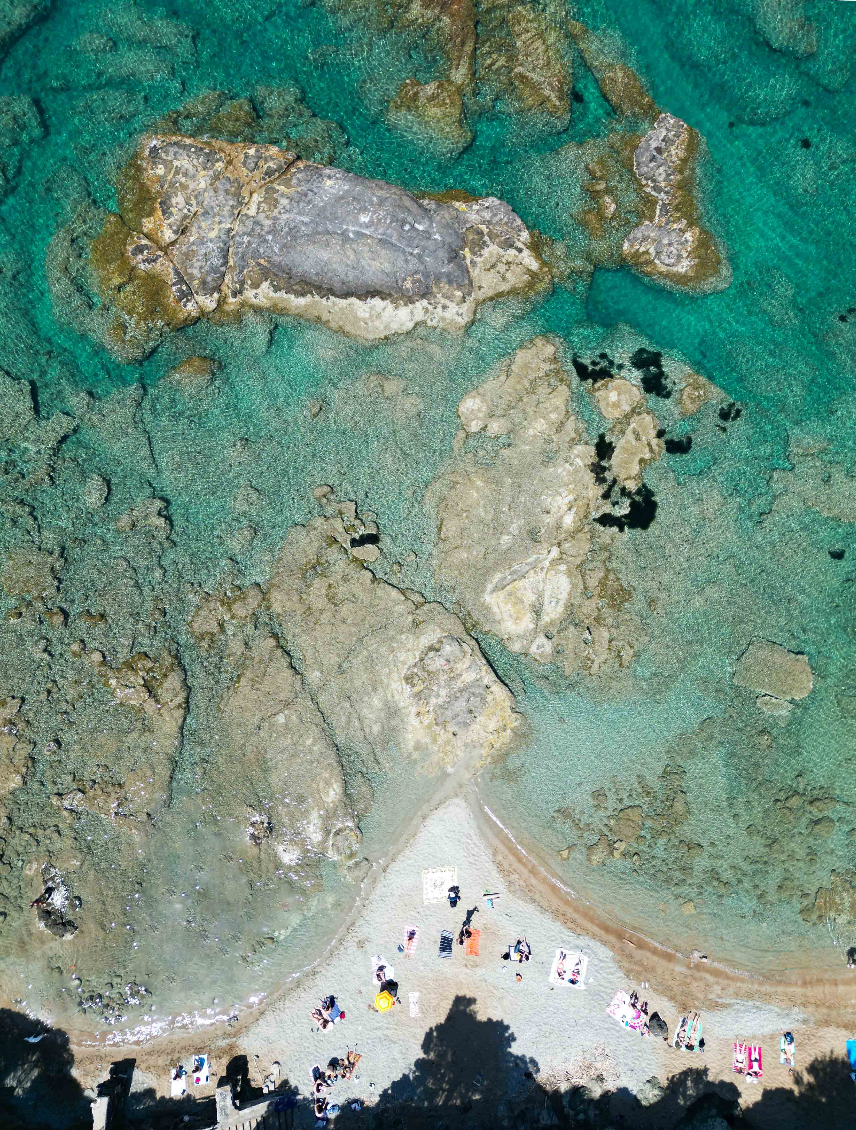 Overhead view of swimmers in the cove at Baia del Quercetano, Tuscany
