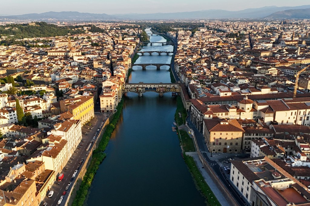 Veduta aerea dell'Arno che attraversa Firenze, con Ponte Vecchio e gli altri ponti in fila fra i tetti della città