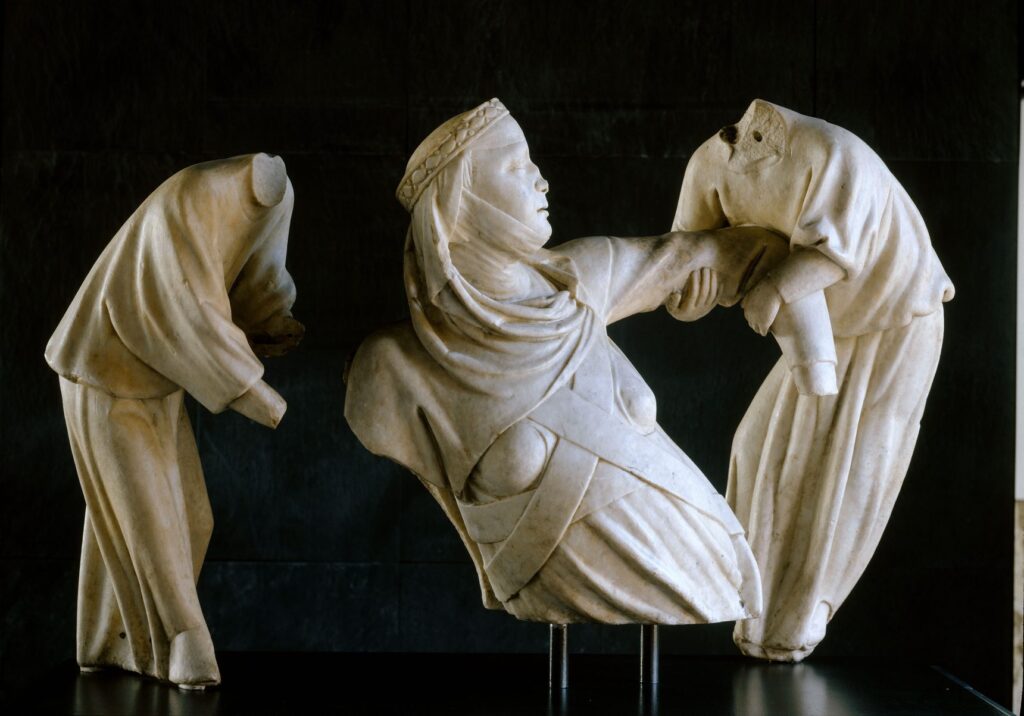 Frammenti del monumento funebre a Margherita di Brabante di Giovanni Pisano: figure panneggiate in marmo bianco su fondo nero
