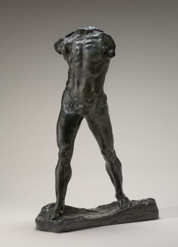 L'Homme qui marche di Auguste Rodin: la figura in bronzo scuro di un uomo senza testa né braccia, fermata nel passo