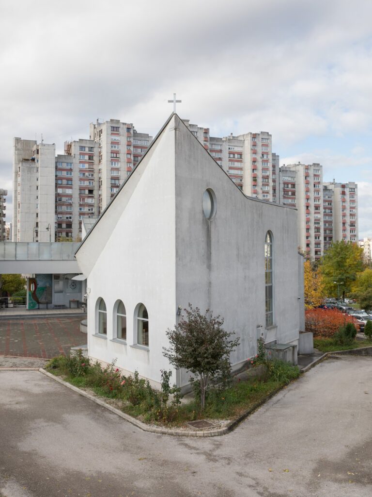 La chiesa cattolica di San Luca Evangelista, bianca e dal tetto spiovente, fra i palazzoni di Alipašino Polje a Sarajevo