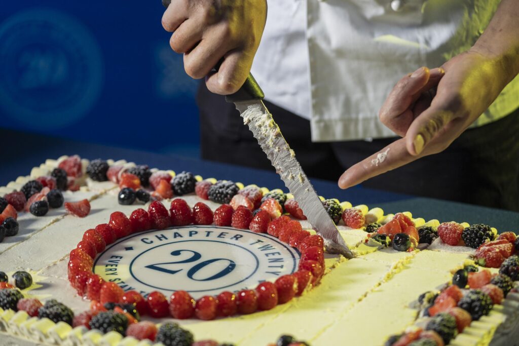 The twentieth anniversary cake with the Chapter Twenty logo and berries, cut at the Hilton Garden Inn Novoli party