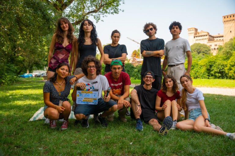 Il gruppo di ragazzi che ha girato Joystick in posa su un prato, alcuni in piedi e altri seduti, uno con il ciak in mano