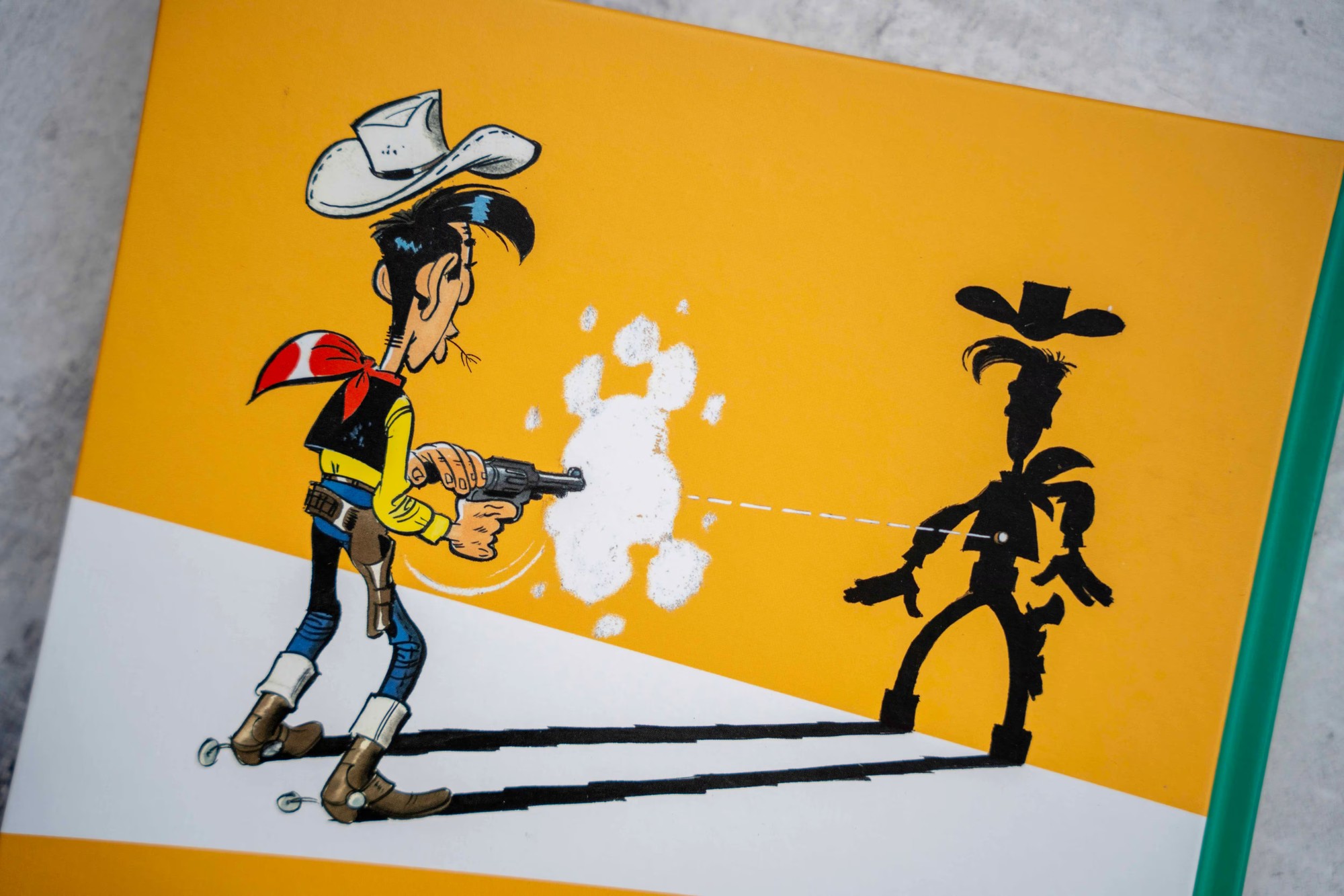 Una tavola di Lucky Luke: il cowboy spara alla sua ombra nera su un fondo giallo acceso