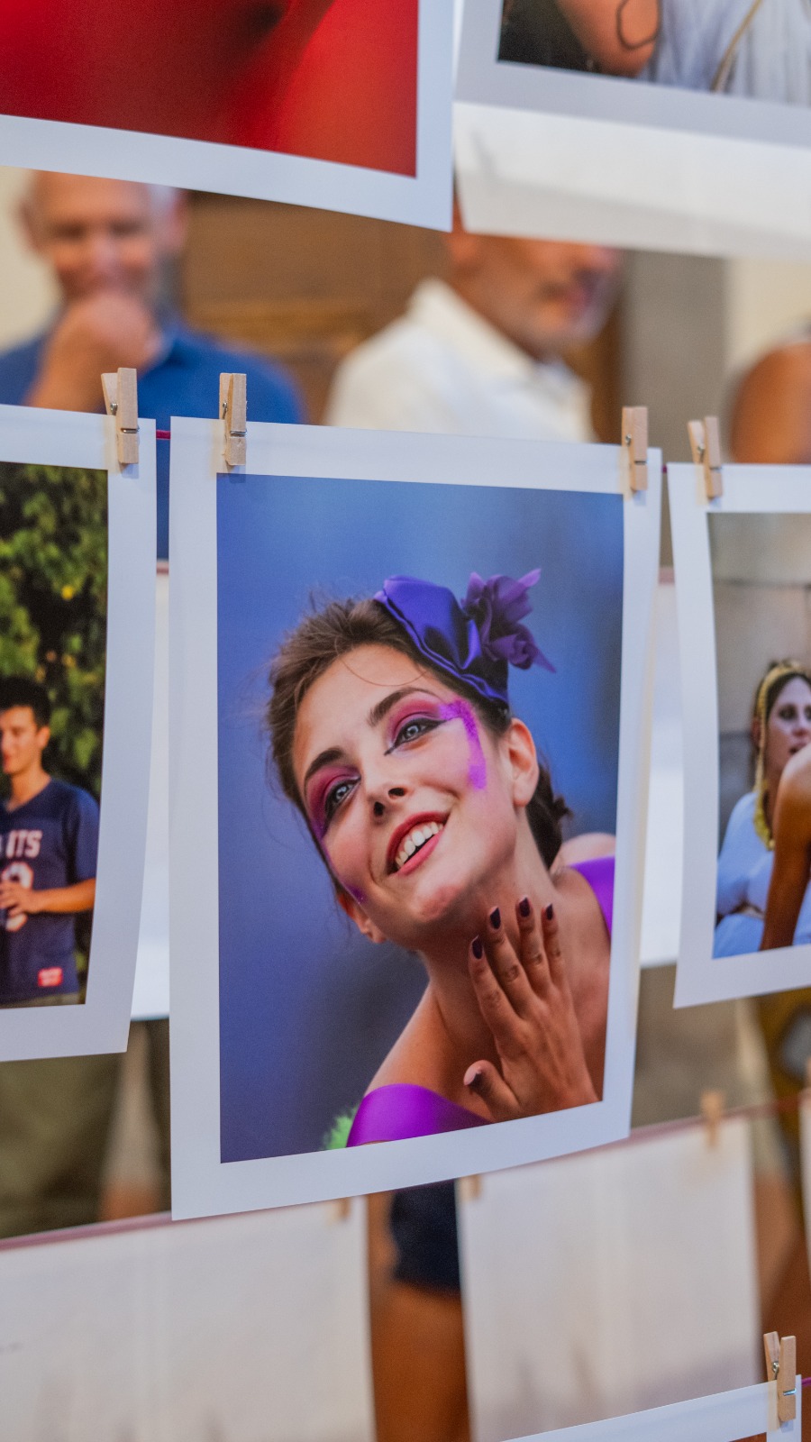 Portraits of Festa dell'Uva participants pegged to a line at the Centenary exhibition in Impruneta