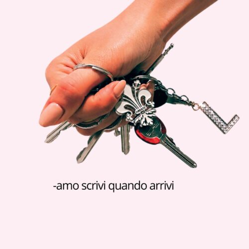 Manifesto con una mano che stringe un mazzo di chiavi fra le dita su fondo rosa e la scritta «-amo scrivi quando arrivi»