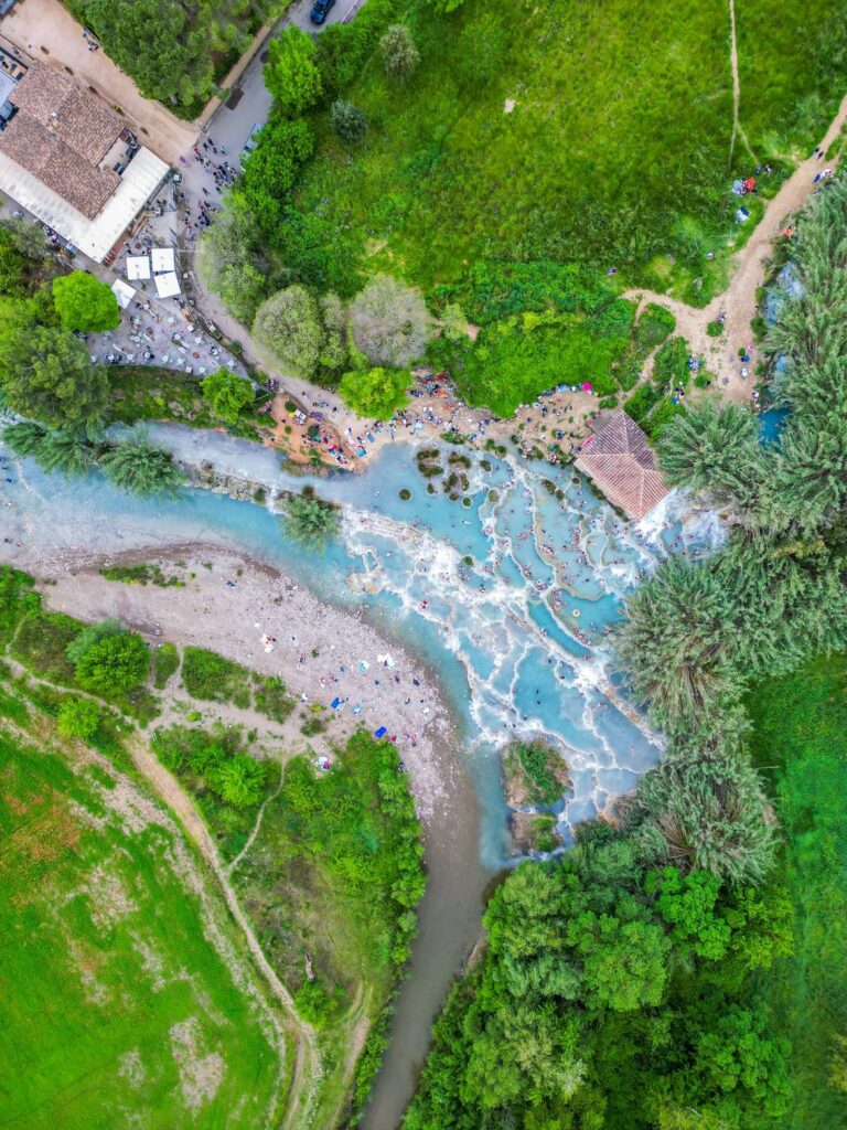 Le Cascate del Mulino di Saturnia viste dall'alto: le vasche azzurre di travertino tra i prati e il mulino