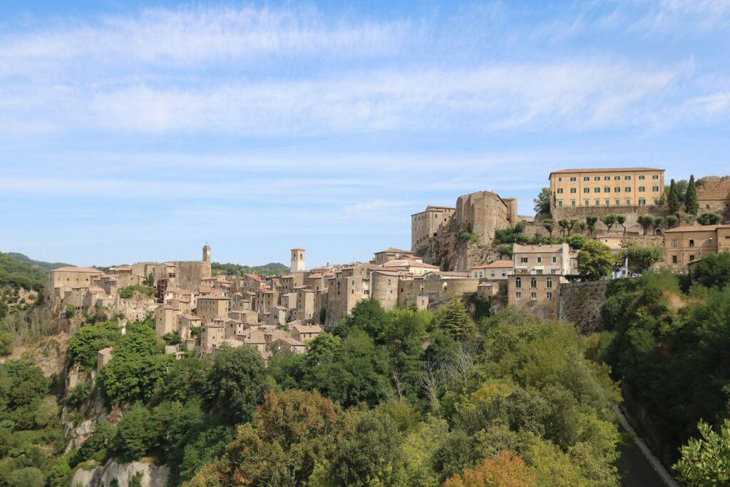 Il borgo di tufo di Sorano sulla rupe, con la fortezza in cima, sopra una valle coperta di boschi