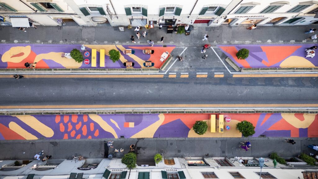 Via Pacinotti a Firenze vista dal drone: la pavimentazione dipinta a forme viola, arancio e sabbia ai lati della strada