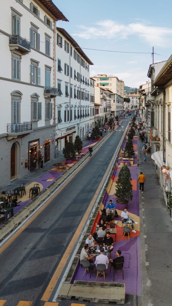 Via Pacinotti a Firenze dall'alto, in obliquo: la pavimentazione dipinta e i tavolini ai lati della strada fra i palazzi