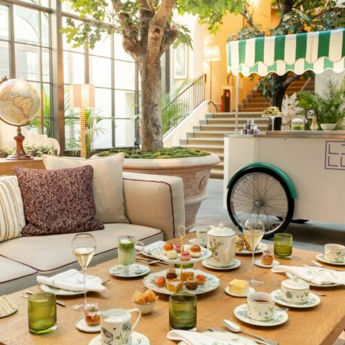 Tavolo per l'Afternoon Tea al Conservatorio di Collegio alla Querce, con tazze, dolci e il carretto a strisce verdi