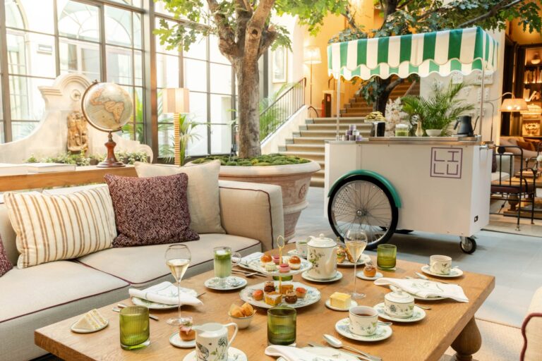 Tavolo per l'Afternoon Tea al Conservatorio di Collegio alla Querce, con tazze, dolci e il carretto a strisce verdi