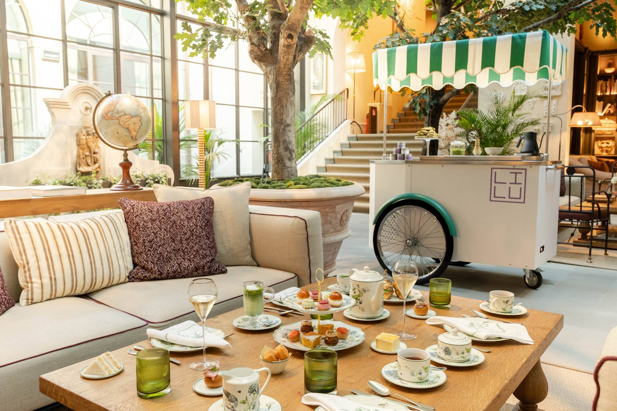 Tavolo per l'Afternoon Tea al Conservatorio di Collegio alla Querce, con tazze, dolci e il carretto a strisce verdi