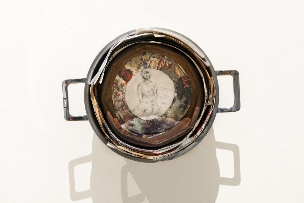 Disegno scultoreo di Benni Bosetto: una pentola consumata vista dall'alto, con dentro il disegno di una figura