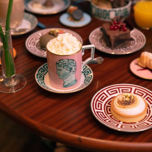 Tavolo del Café Ginori apparecchiato per il brunch con porcellane Ginori, cappuccino con panna, pasticcini e succo d'arancia