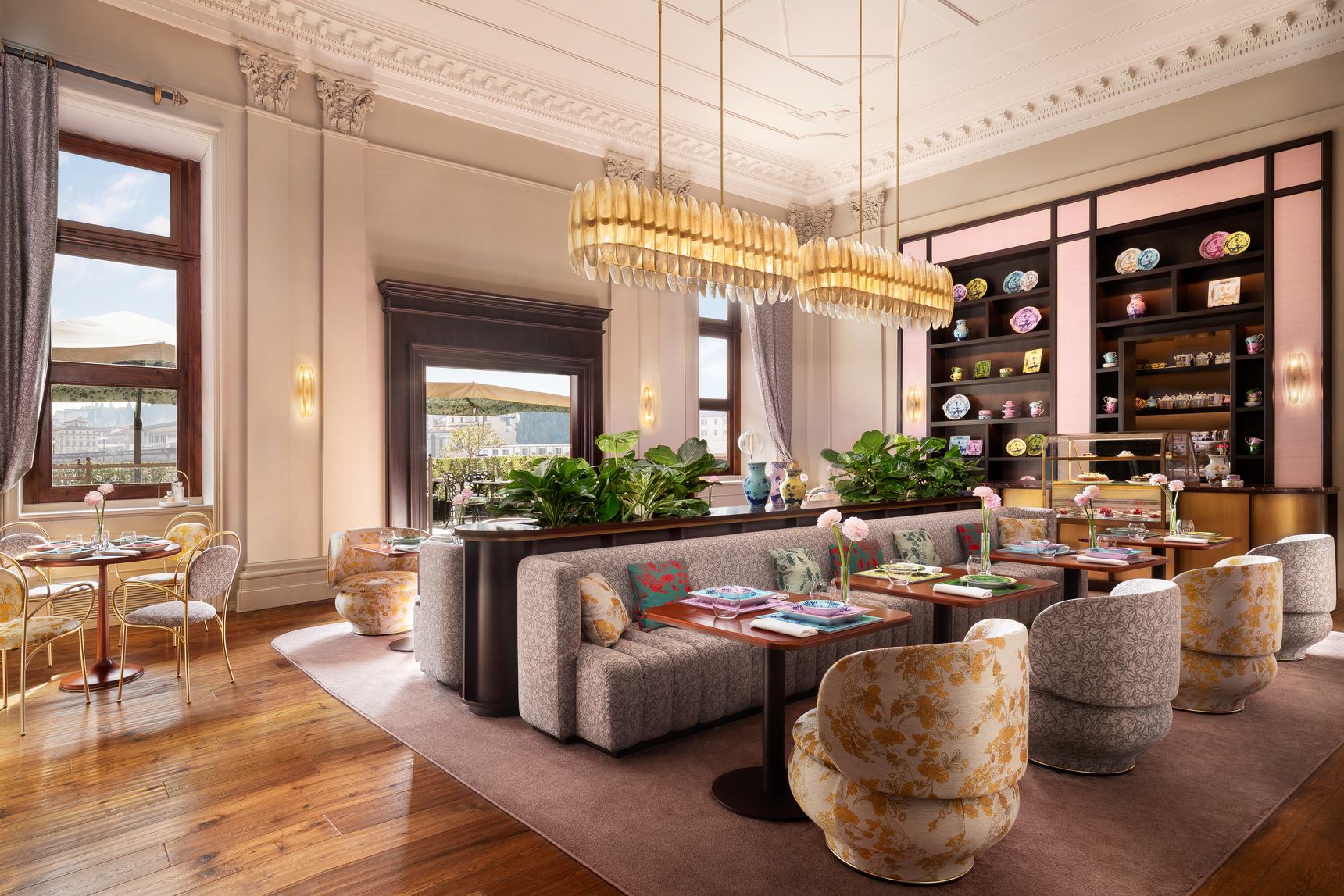 The Café Ginori dining room at the St. Regis Florence, with chandeliers, banquettes and display cases of Ginori porcelain