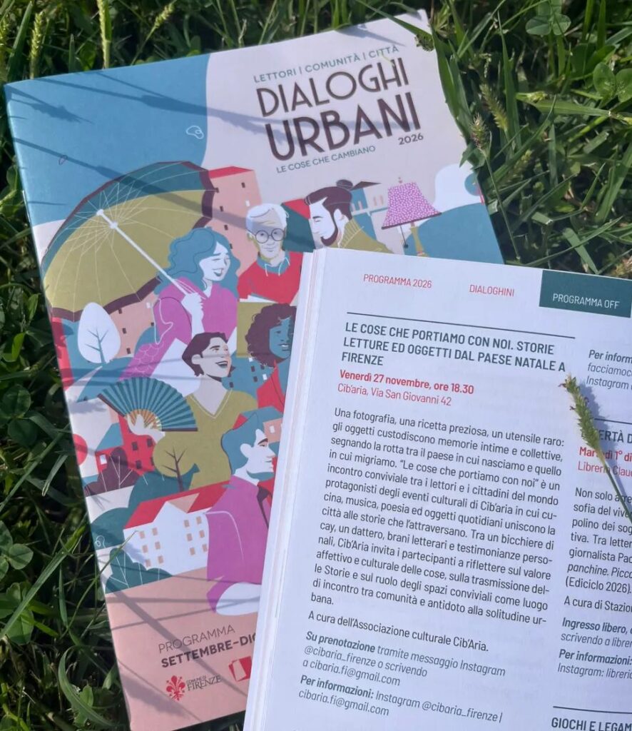 L’opuscolo Dialoghi Urbani appoggiato sull’erba, aperto sulla pagina dell’incontro Le cose che portiamo con noi