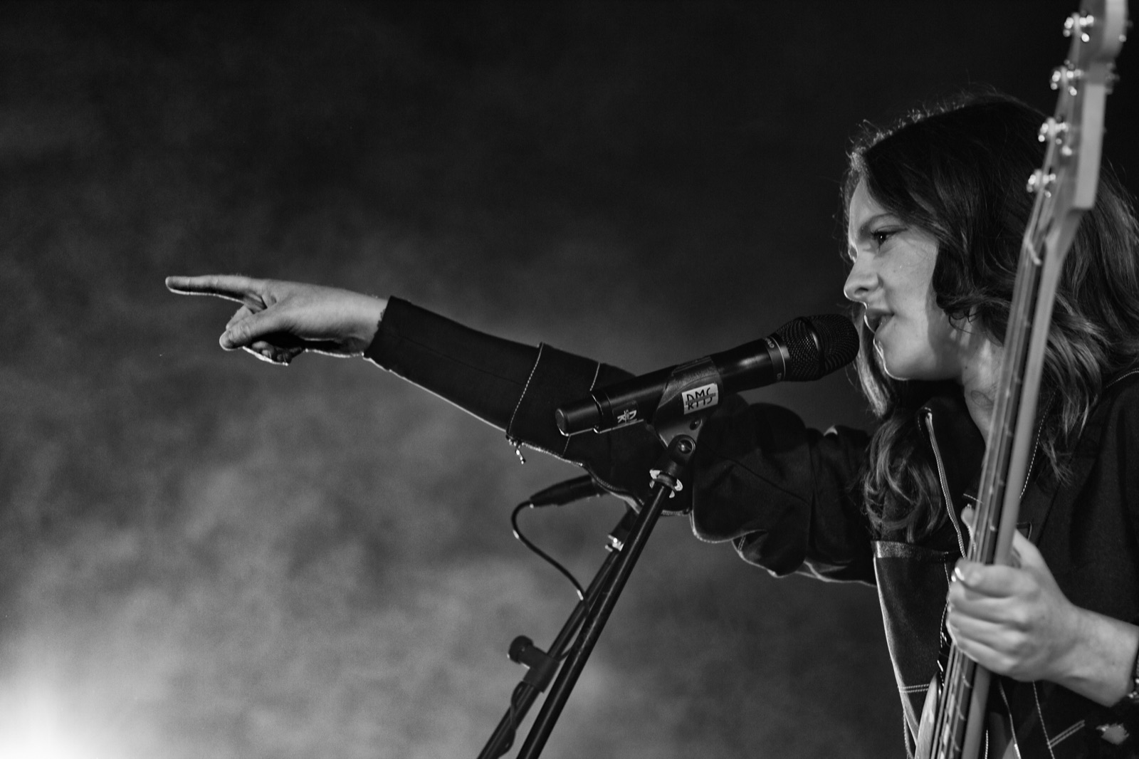 Francesca Michielin in bianco e nero al microfono, col basso a tracolla, indica un punto davanti a sé