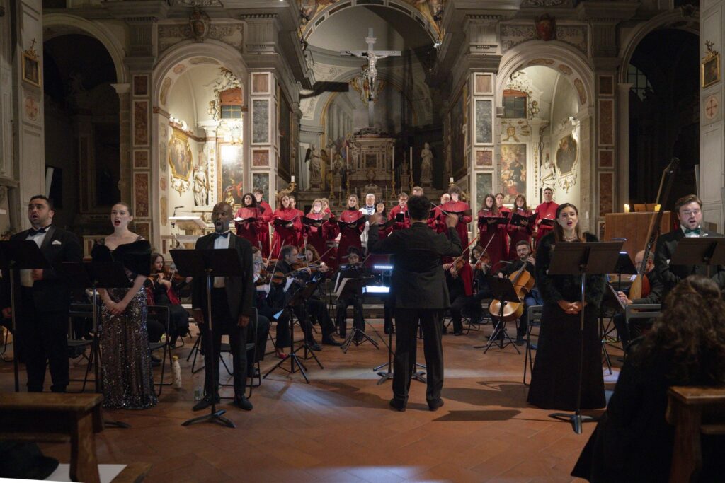 Solisti, coro e orchestra schierati in una chiesa di Firenze durante il concerto di Natale della New Generation Foundation