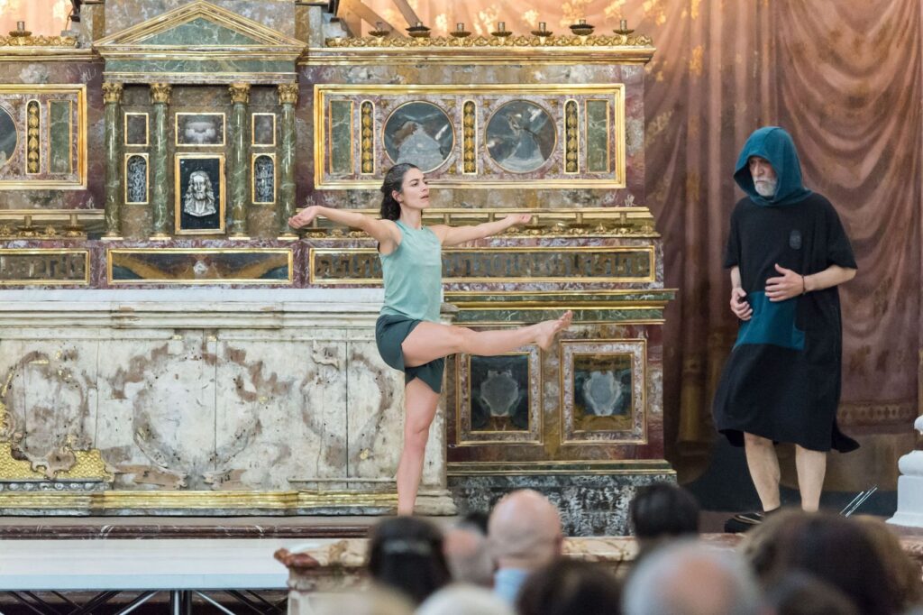 Le forme del rito di Roberto Zappalà: una danzatrice in equilibrio su una gamba davanti a un altare dorato, col pubblico